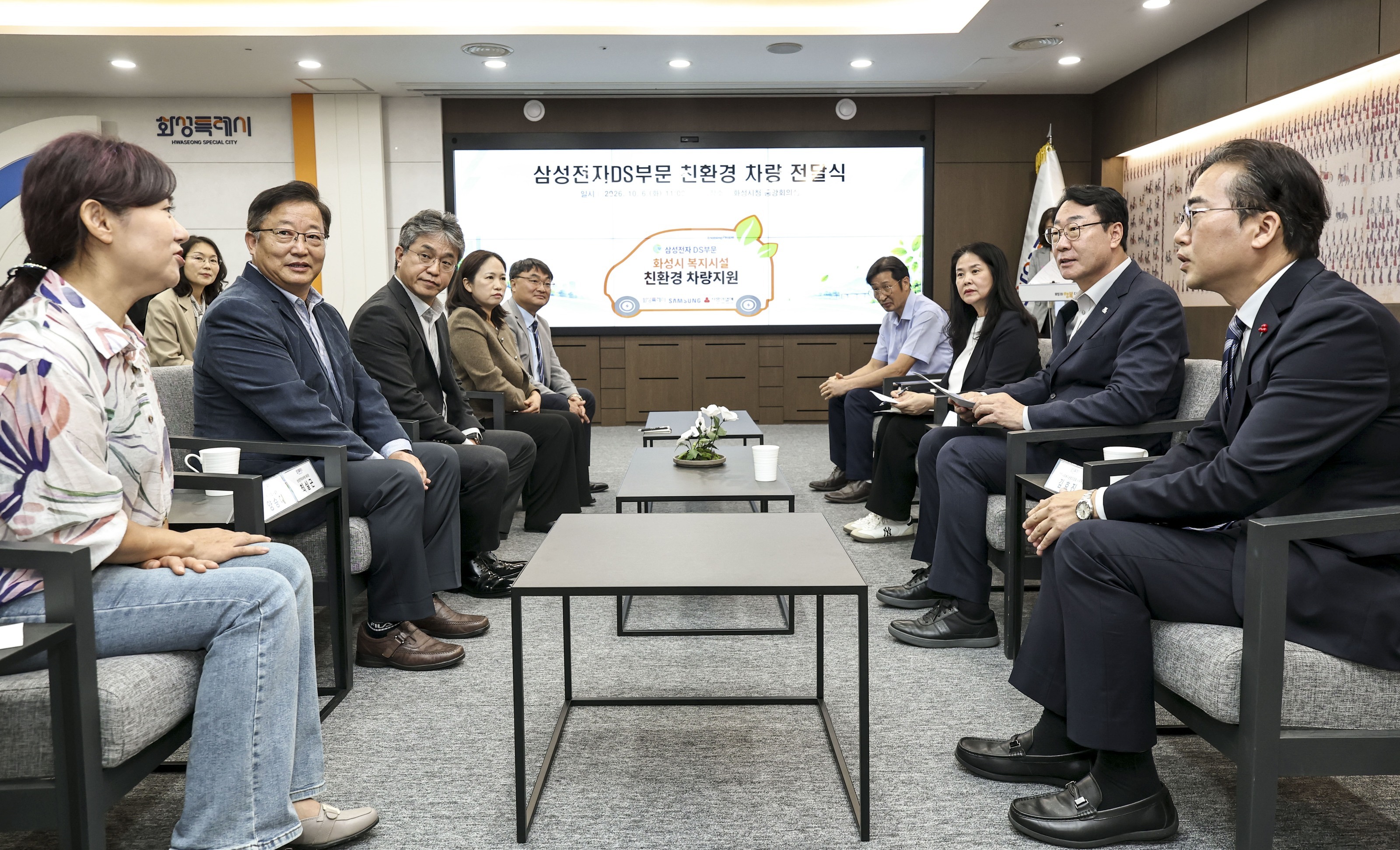 Mayor Jung Myeong-geun of Hwaseong Special City engages in conversation with officials from Samsung Electronics DS Division and welfare facilities at the eco-friendly vehicle delivery ceremony on the 6th. Provided by Hwaseong City