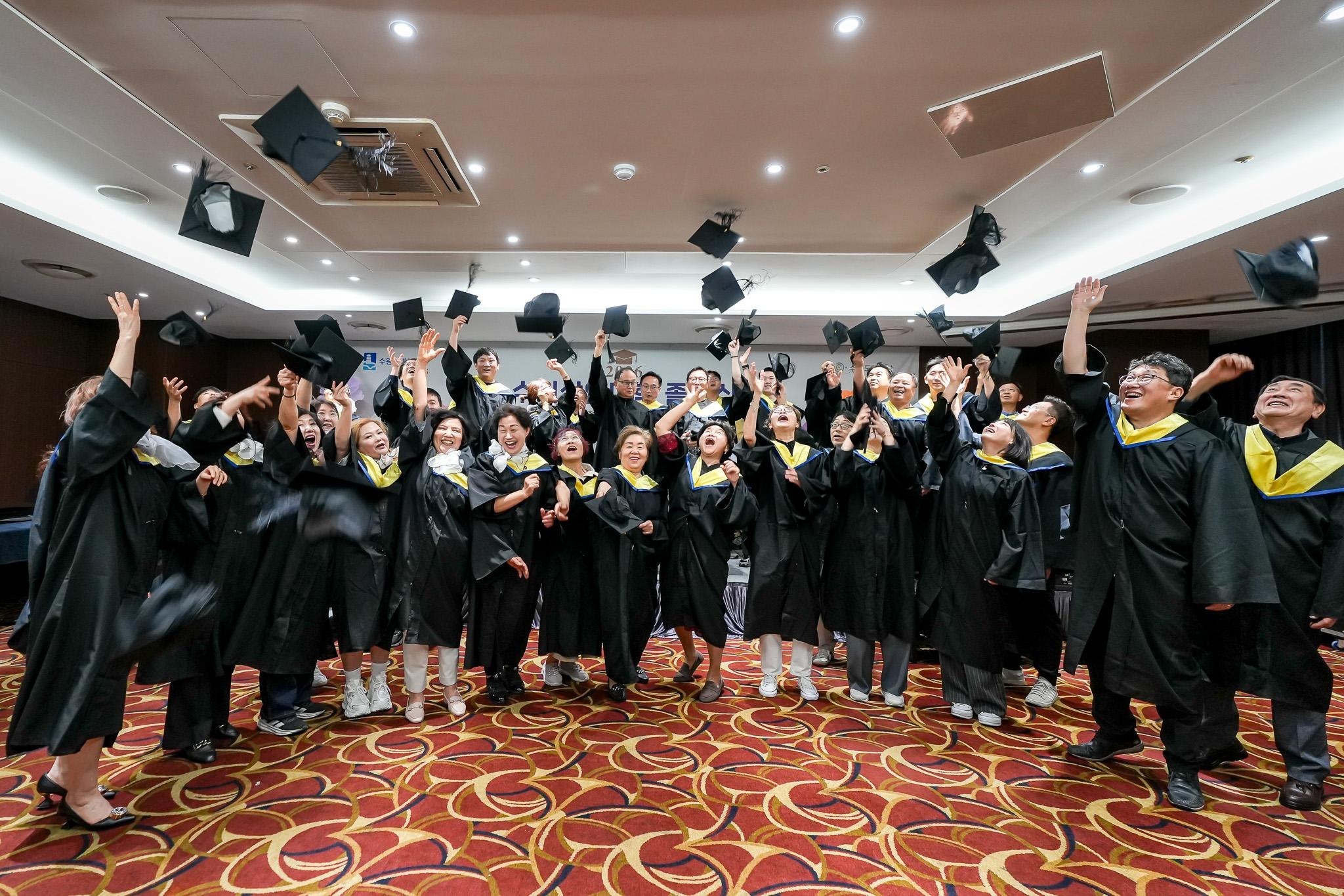 Những người hoàn thành khóa Đại học Thương nhân Suwon năm nay đang chụp ảnh kỷ niệm trong lễ tốt nghiệp bằng cách vung mũ tam giác. /Thành phố Suwon