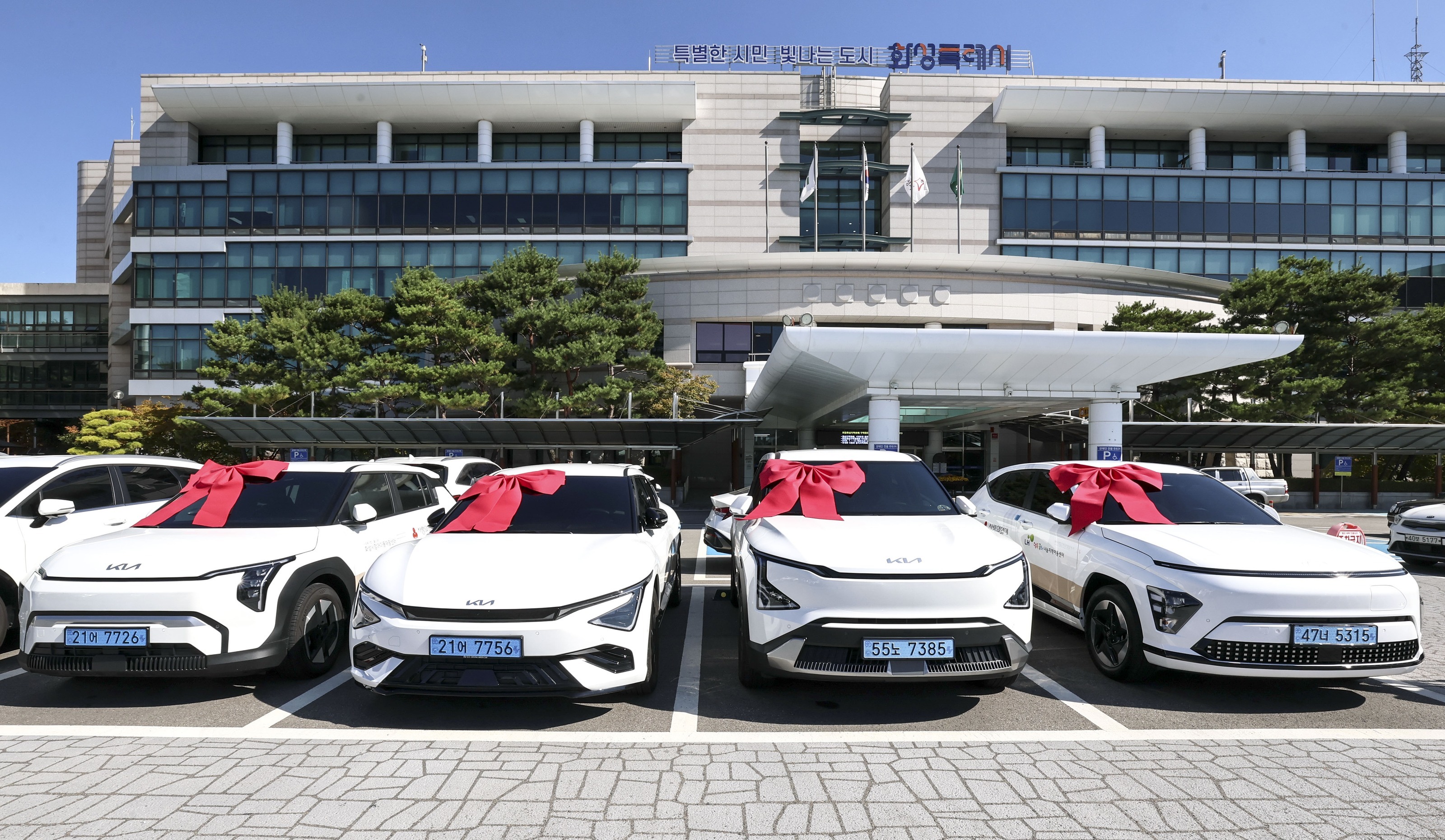 Four eco-friendly vehicles procured with donations from Samsung Electronics DS Division employees' 'Walk of Love Campaign' are placed in front of Hwaseong Special City Hall. Provided by Hwaseong City