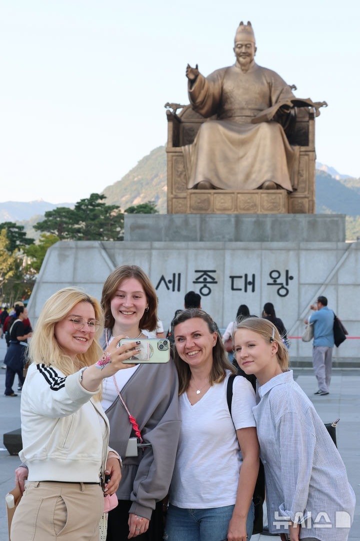 [Seoul=Newsis] Reporter Kim Geum-bo = On the afternoon of October 8, a day before Hangeul Day, tourists leave memories in front of the King Sejong statue at Gwanghwamun Square in Jongno-gu, Seoul. 2026.10.08. kgb@newsis.com