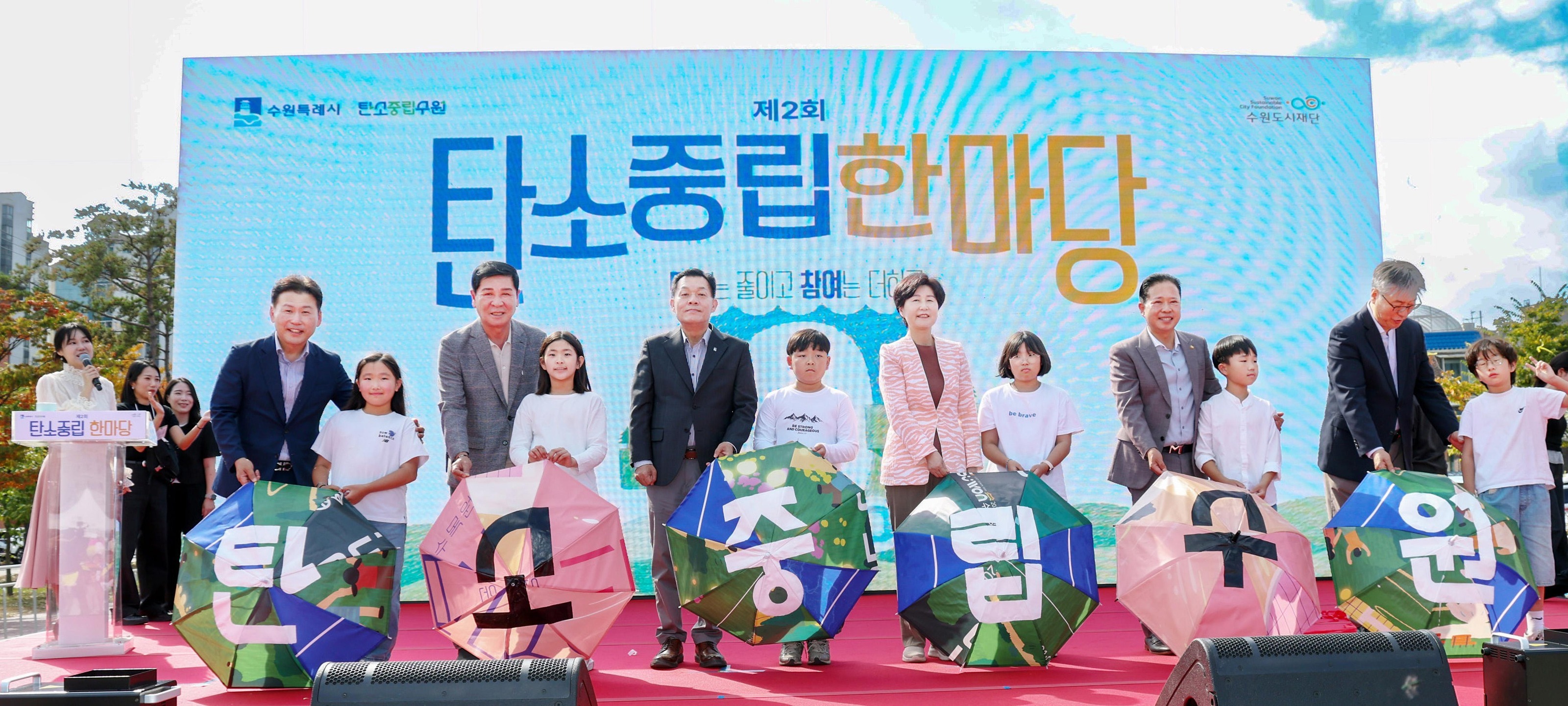 Suwon Mayor Lee Jae-joon, Vice-Chairman Yu Jae-gwang of Suwon Metropolitan Council, Representative Baek Hye-ryeon (Suwon District 3), and Park President Lee Byung-jin of the Suwon Urban Foundation perform 'Carbon Neutral Suwon!' with young people. Courtesy of Suwon City