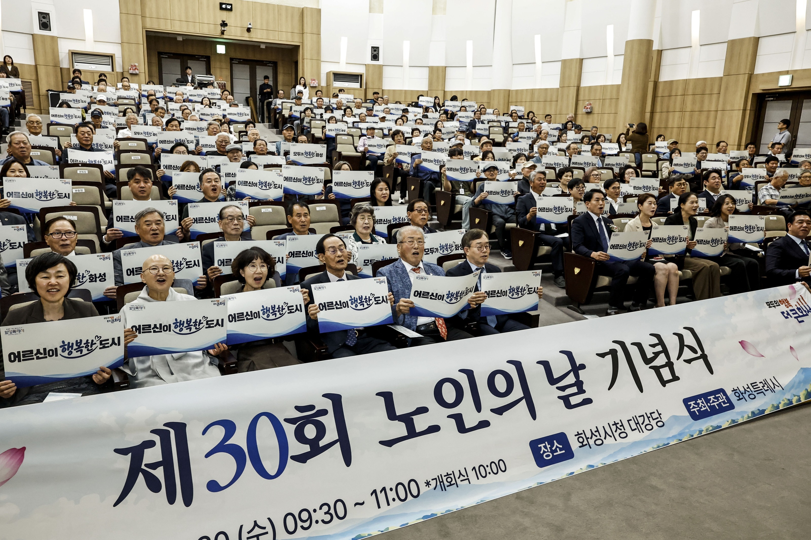 30일 화성시청 대강당에서 열린 제30회 노인의 날 기념식에서 참석자들이 피켓을 들고 기념 퍼포먼스를 하고 있다. 화성시 제공