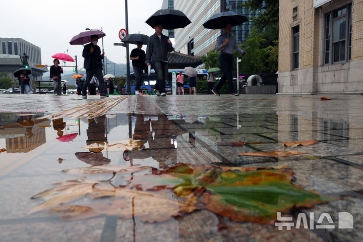 [Seoul=News 1] Phóng viên Ko Seung-min = Vào ngày 13, khi mưa rơi ở khu vực Seoul, những nhân viên văn phòng đi làm đang vội vã bước chân trên giao lộ Quảng trường Gwanghwamun, Seoul. 2026.10.13. kkssmm99@newsis.com