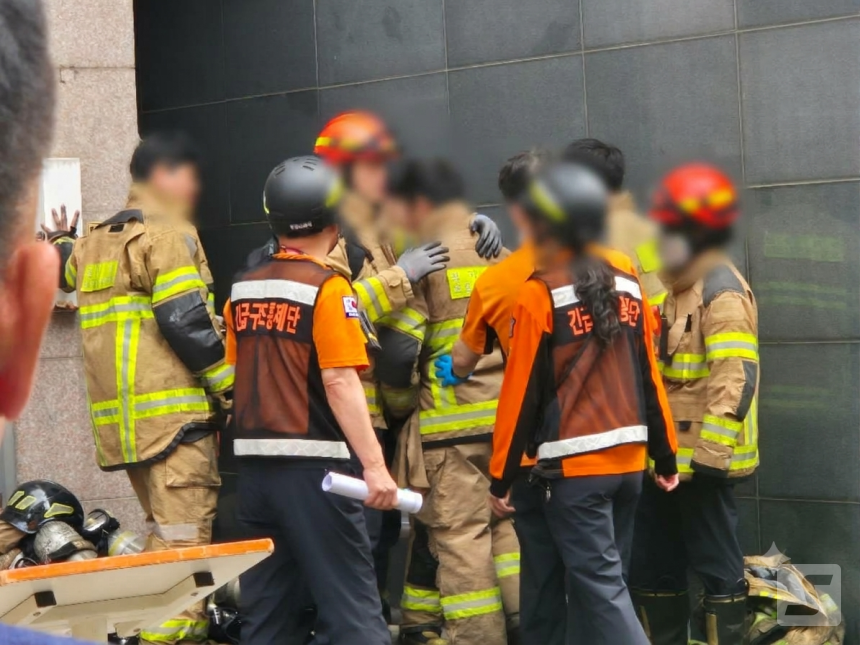 On the 16th, firefighters who completed fire suppression at a metal parts painting factory in Bucheon, Gyeonggi Province, check on their colleague's condition