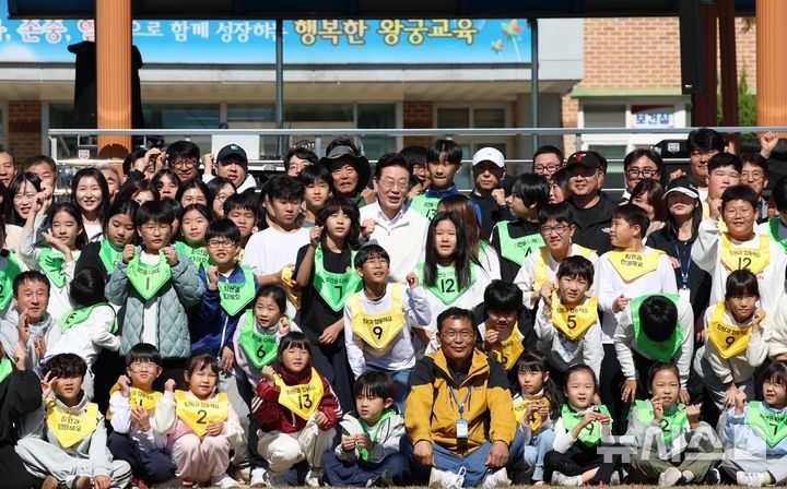 [Iksan=Newsis] Phóng viên Kim Jin-ah = Tổng thống Lee Jae-myung đang chụp ảnh kỷ niệm cùng các học sinh trong Lễ hội thể thao Trường hạnh phúc mùa thu diễn ra tại Trường tiểu học Wanggung, Iksan, Tỉnh Bắc Jeolla vào ngày 22. 2026.10.22. bluesoda@newsis.com